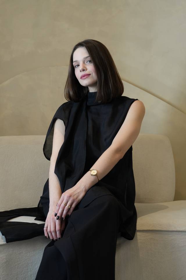 Look preto fluido com relógio dourado